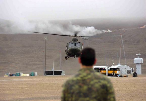 A Canadian solider observes a helicopter land near the downed 737. Department of National Defence, Master Cpl. Randy Burnside. 