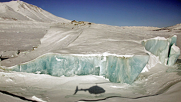 A helicopter's shadow is displayed on the Lowell Glacier in Kluane National Park in the Yukon. The park was designated a UNESCO World Heritage Site in 1980. (Chuck Stoody / Canadian Press)