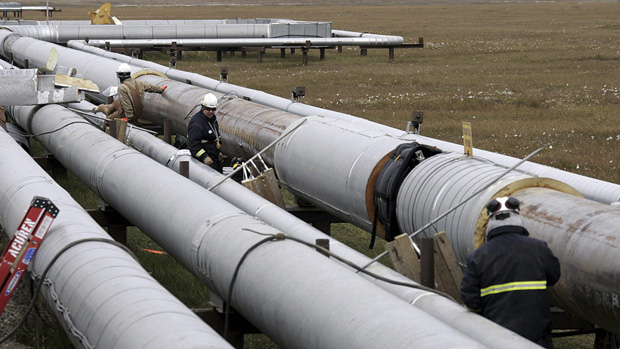 BP workers remove insulation from an oil transit pipeline at the Prudhoe Bay oil field on Alaska's North Slope Aug. 18, 2006 as other workers use ultrasound to test for weakness in the pipe due to corrosion. (Associated Press)