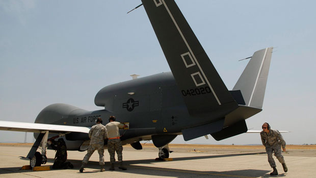 U.S. air force airmen work on getting RQ-4 Global Hawk Block-20 into its hangar. U.S. defence contractor Northrop Grumman is proposing to sell Global Hawk drones modified to meet the rigours of flying in the Arctic to the Canadian government. (Chris Kaufman/Appeal-Democrat/Associated Press)