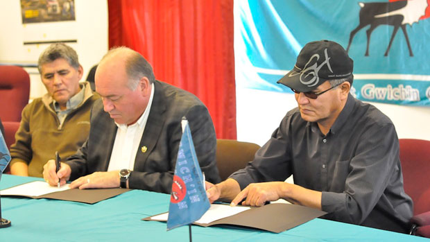 Minister Robert C. McLeod, who is also the MLA for Inuvik Twin Lakes, looks on as N.W.T. Premier Bob McLeod and Gwich'in Tribal Council president Robert Alexie Jr. sign the devolution Agreement in Principle in Aklavik, N.W.T., last week. (Philippe Morin/CBC)