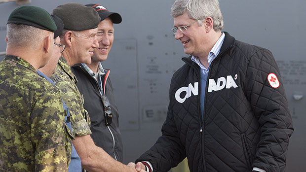 Prime Minister Stephen Harper shakes hands with Gen. Walk Natynczyk, chief of the defence staff, as Defence Minister Peter MacKay looks on, after arriving in Churchill, Man. Thursday. (Adrian Wyld/Canadian Press)