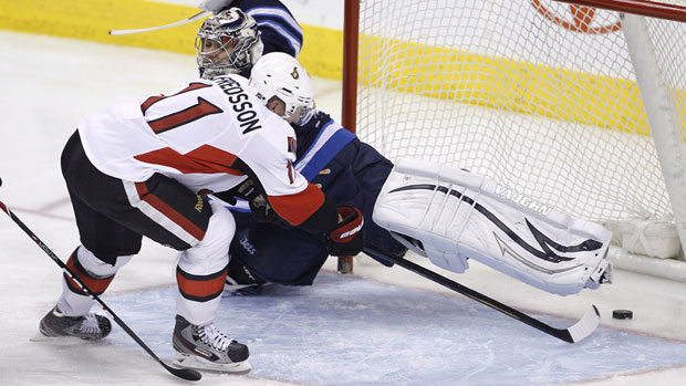 The Ottawa Senators' Daniel Alfredsson puts the puck past Winnipeg Jets' goalie Ondrej Pavelec. Alfredsson is one of the NHL players who has expressed interest in playing in the charity games in the North. (Trevor Hagan/Canadian Press)