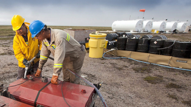 Two local men work at the fuel storage site at the proposed Kiggavik uranium mine, near Baker Lake, Nunavut. (The Canadian Press)