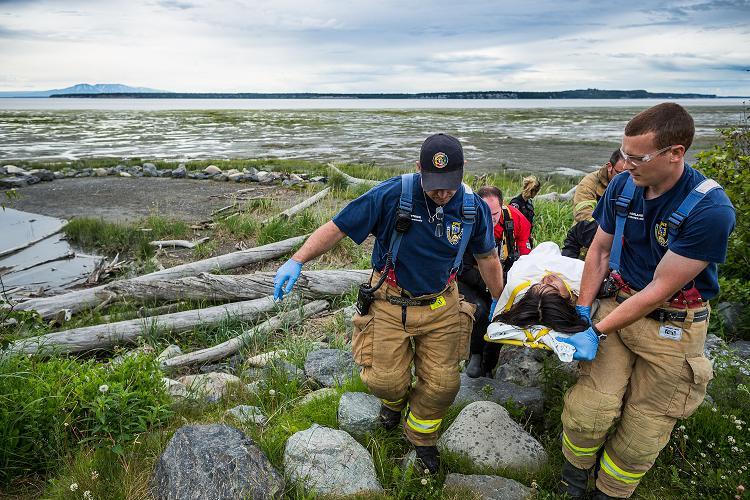 A man, barely responsive, is transported to an ambulance after he and his companion were rescued from the mudflats near downtown Anchorage. July 6, 2012. Photo: Loren Holmes. Alaska Dispatch. 