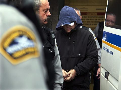 Sub.-Lt. Jeffrey Paul Delisle is escorted from provincial court in Halifax on Tuesday, Jan. 17, 2012. The Canadian navy intelligence officer, charged with communicating information to a foreign entity, faces charges under the Security of Information Act.Photo: Andrew Vaughan. The Canadian Press.