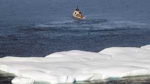A Canadian tugboat tows an iceberg away to avoid a possible collision with oil drilling platforms in the North Atlantic Ocean near the Grand Banks in 2003. (Gary C. Knapp/Associated Press)