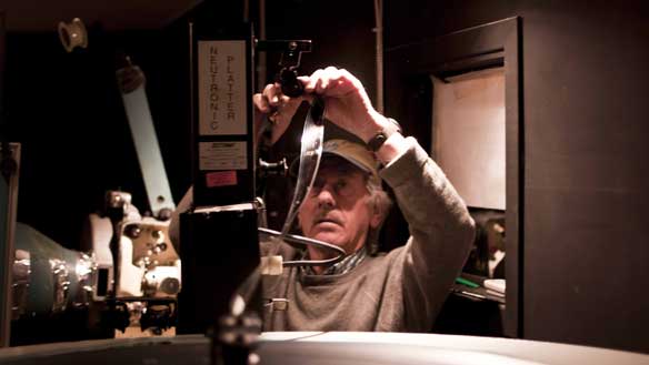 Bryan Pearson operates the current film projector at the Astro Theatre in Iqaluit. The 1950s-era machine will be replaced in a few weeks by a digital projector that will, among other things, allow Pearson to show 3D movies. (Chris Harbord/CBC)