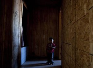 A young boy stands in the hallway of a house condemned due to structural and mold problems where four people live in Attawapiskat, Ont., Tuesday November 29, 2011. Adrian Wyld, The Canadian Press.
