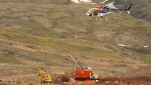 A helicopter passes over excavation equipment at the Mary River exploration camp, the site of a proposed iron mine on northern Baffin Island, in this Aug.17, 2006 photo. Nunavut is leading the North in terms of mineral exploration dollars spent in 2011. (Vinnie Karetak/The Canadian Press)