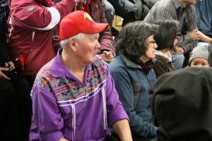 A man wearing an intricately embroidered shirt watches the games. Photo by Levon Sevunts