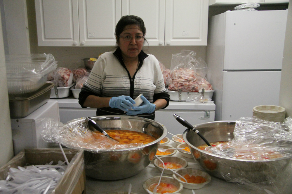 Volunteers prepare food for the community feast at the hand games. Photo by Levon Sevunts