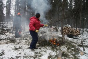 France and Doug are burning branches and brush to protect their log house from summer forest fires.