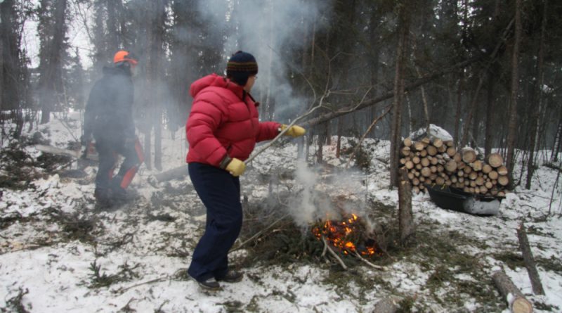 France and Doug are burning branches and brush to protect their log house from summer forest fires.