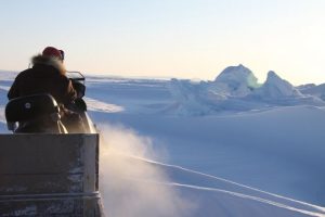 Inuit hunter and guide Elijah Pallituq drives his snowmobile over an ice ridge created by the moving plates of sea ice. Photo by Levon Sevunts.