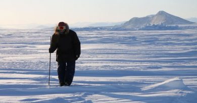 Inuit hunter and guide Elijah Pallituq walks on sea ice checking for seal breathing holes along the cracks in sea ice. Photo by Levon Sevunts.