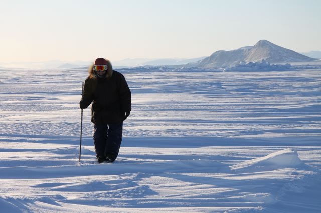 Inuit hunter and guide Elijah Pallituq walks on sea ice checking for seal breathing holes along the cracks in sea ice. Photo by Levon Sevunts.