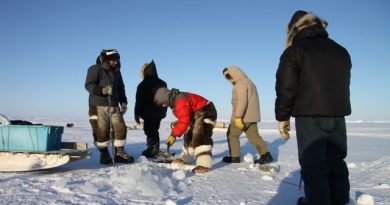 Inuit hunters cut a hole in the sea ice to set up nets to catch fish and seals. Photo by Levon Sevunts.