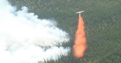 Un avion-citerne déverse sa cargaison de liquide ignifuge près d'un brasier au Yukon. (Yukon Wildland Fire management)