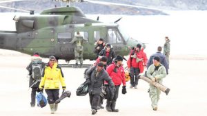 Some of the rescued hunters and tourists walk away from a military helicopter in Arctic Bay, Nunavut. (Photo courtesy of Niore Iqalukjuak)