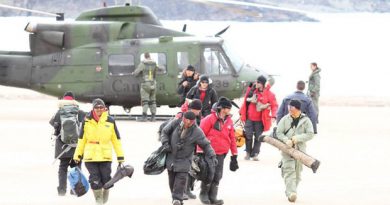 Some of the rescued hunters and tourists walk away from a military helicopter in Arctic Bay, Nunavut. (Photo courtesy of Niore Iqalukjuak)
