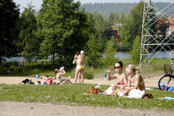 Sun-worshippers at Lake Tuomiojärvi in the municipality of Jyväskylä in central Finland. (Terri Niemi / Yle)