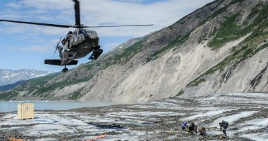 Members of a specialized investigative team from the Join POW/MIA Accounting Command wait as a UH - 60 Blackhawk from Joint Base Elmendorf-Richardson comes in for a landing to transport them back after a day of assessing a historic aircraft crash site. The mission of the Joint POW/MIA Accounting command is to conduct global search, recovey and laboratory operations to identify unaccounted-for Americans from past conflicts in order to support hte Department of Defense's personnel accounting efforts. (Clifford Bailey / US Navy)