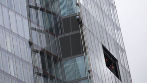 One of six Greenpeace protesters climbs up the Shard, the tallest building in western Europe, as workers look from a window during a protest against the oil company Shell's drilling in the Arctic. (Sang Tan/Associated Press)