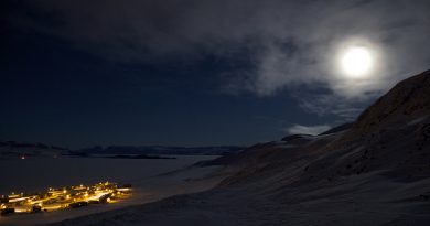Part of Arctic Bay glows beneath the hills surrounding the community under the almost full moon.(Clare Kines)