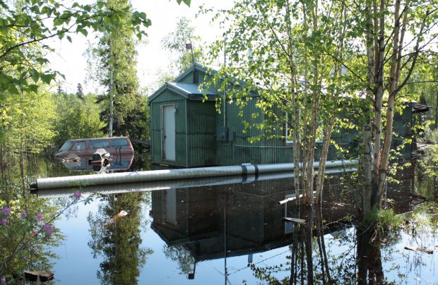 After being told that her home, pictured here in June sitting in a lake of polluted, sewage-tainted water, was not a total loss and could be repaired enough to live in again, Jennifer Hildebrand and her community were filled with disbelief. So they took action. (Laurel Andrews/Alaska Dispatch)