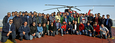 The crew of the Amundsen pose with the helicopter that crashed on Monday, in this undated photo. The crew aboard the icebreaker usually consists of 40 scientists and 40 ship crew, who operate as a tightly knit group. (ArcticNet)