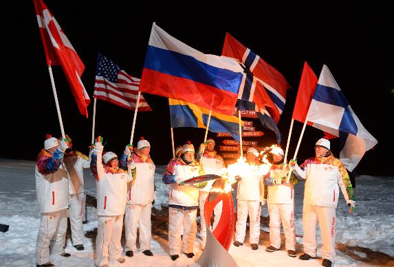 Arctic explorer Artur Chilingarov (C) lighting the Olympic flame at the North Pole. (Sochi 2014 Organizing Committee / AFP)
