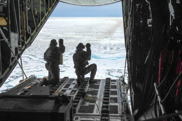 Petty Officer 3rd Class Jesse Sanchez and Petty Officer 3rd Class Nathan Matthews, both aviation maintenance technicians, prepare to deploy two of six sensors from an Air Station Kodiak HC-130 Hercules airplane north of Barrow, Alaska. The sensors gather data about the Arctic Ocean as they descend through the water column. They are deployed through a partnership between the U.S. Coast Guard and the University of Washington's Polar Science Center. July 16, 2013 (Sara Mooers / USCG/ Alaska Dispatch)