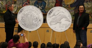 Royal Canadian Mint Board of Directors member Claude Bennett and Cape Dorset artist Tim Pitsiulak unveil new 25-cent coins celebrating the 100th anniversary of the Canadian Arctic Expedition and Life in the North at Kullik Illihakvik Elementary school in Cambridge Bay. (Royal Canadian Mint)