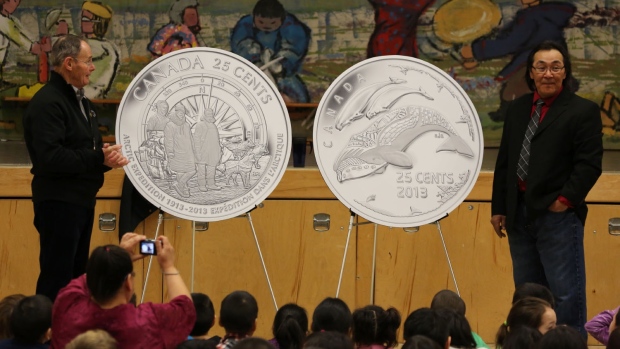Royal Canadian Mint Board of Directors member Claude Bennett and Cape Dorset artist Tim Pitsiulak unveil new 25-cent coins celebrating the 100th anniversary of the Canadian Arctic Expedition and Life in the North at Kullik Illihakvik Elementary school in Cambridge Bay. (Royal Canadian Mint)