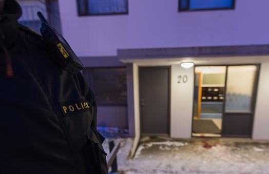 A police officer stands guard at a house where a man was shot dead by poilce in Reykjaiík on December 2, 2013. (Halldor Kolbeins / AFP)