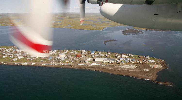 A Coast Guard C-130 flys past a coastal village on the Chukchi Sea near Kotzebue, Alaska. (Al Grillo / AP)