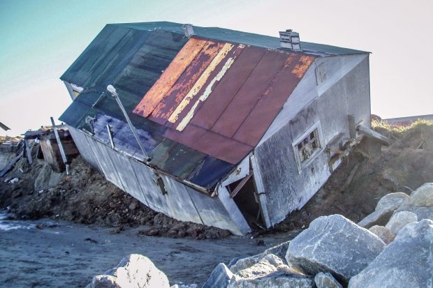 A home in Shishmaref falls into the sea. Shishmaref is highly susceptible to coastal erosion. (Courtesy Tony Weyiouanna / Alaska Dispatch)