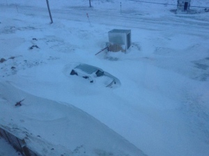 A car buried in a snowdrift. Winds were still raging when people in Iqaluit woke up Wednesday morning, expecting to find damage. (Kenny Bell)