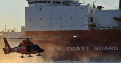 A Coast Guard helicopter crew lands on frozen sea ice in front of the Coast Guard Cutter Healy outside the Port of Nome on Jan. 18, 2012. (U.S. Coast Guard)