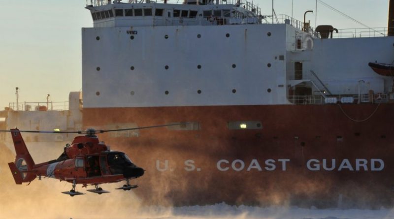 A Coast Guard helicopter crew lands on frozen sea ice in front of the Coast Guard Cutter Healy outside the Port of Nome on Jan. 18, 2012. (U.S. Coast Guard)