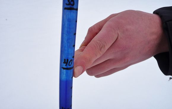 A frost tube, where the dark blue methylene liquid gets lighter as the earth freezes. (Yle)