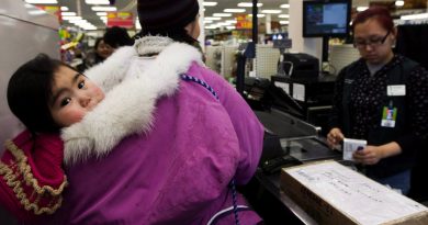 Food security is an issue in communities across the North. Here, Pauline Kadjuk, 1, is carried in a Amautik by her mother Brittany Ikulik, middle, while paying for groceries at the Northern store in the small town of Baker Lake, Nunavut. (Nathan Denette / The Canadian Press)