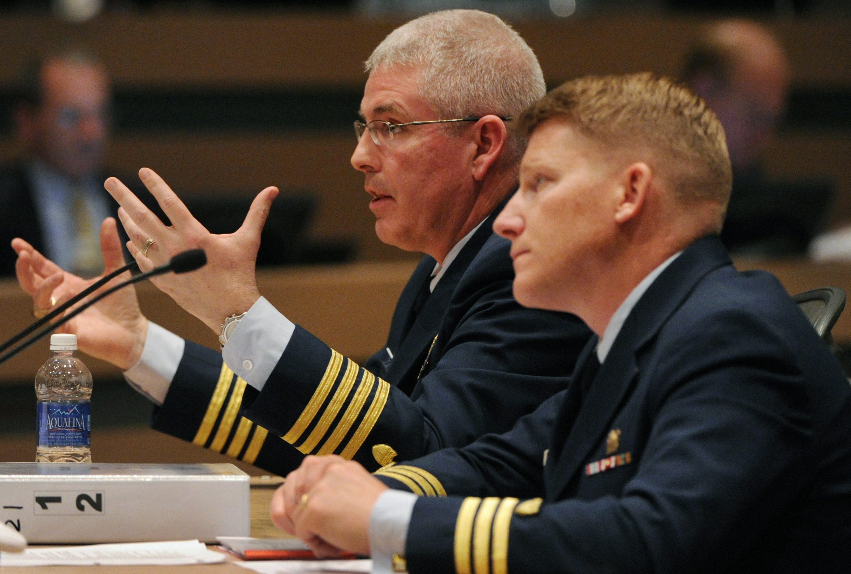 Capt. Paul Mehler III, left, commander of Coast Guard Sector Anchorage, testifies on Wednesday, May 29, 2013, during the formal marine casualty investigation hearing into Shell's conical drilling rig Kulluk grounding on Sitkalidak Island, Alaska, during severe weather on Dec. 31, 2012.  Coast Guard lawyer Cmdr. William Dwyer listens at right.  (Bill Roth, Pool, Anchorage Daily News/AP)