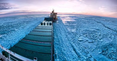 Icebreaker towing cargo ship through thick ice-field in the European Arctic. What kind of shipping traffic will the North American Arctic experience with the changing climate? (iStock)