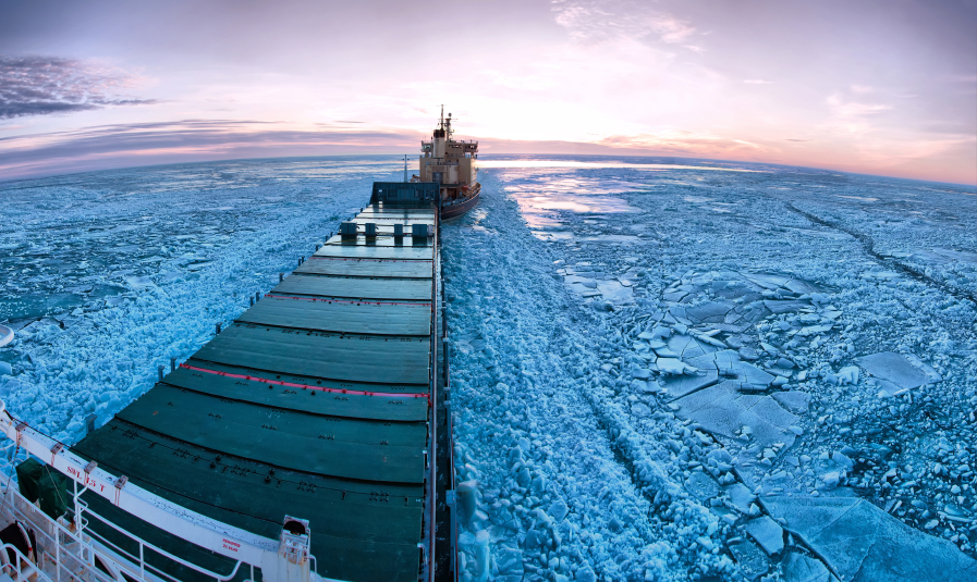Icebreaker towing cargo ship through thick ice-field in the European Arctic. What kind of shipping traffic will the North American Arctic experience with the changing climate? (iStock)