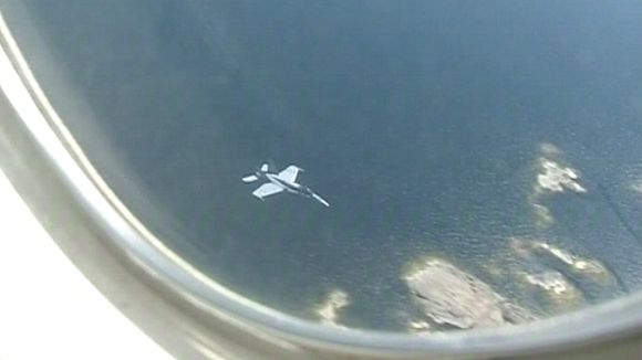 A Finnish Hornet fighter jet seen from the window of a plane. (Yle)