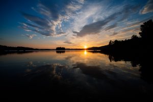 The sun is reflected in the Borgsjoen lake as it sets behind the mountains in Erikslund on July 5, 2014. (Jonathan Nackstrand / AFP / Getty Images)