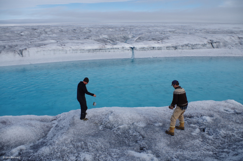 Throwing a level logger to measure temperature and pressure into a supraglacial river, Greenland. (Mia Bennett / August 2014)