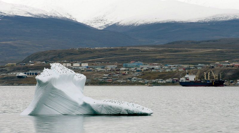 Ice floats past a cargo ship and the hamlet of Pond Inlet in Canada's eastern Arctic in August 24, 2014. (Adrian Wyld / The Canadian Press)